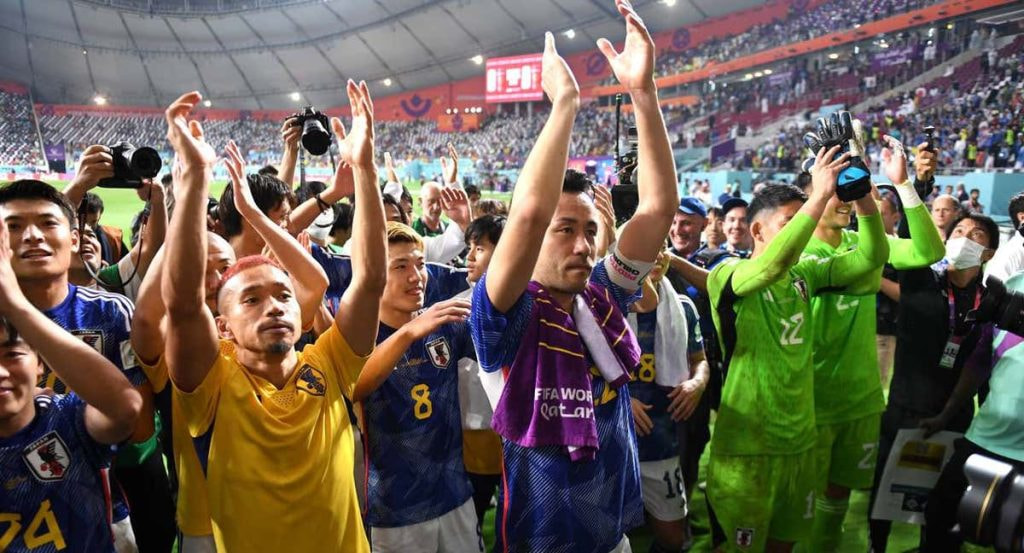 Los jugadores japoneses celebran ante su afición la clasificación a octavos de final tras vencer a España.
