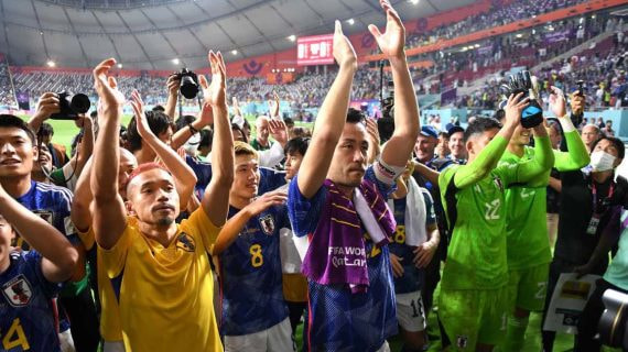Los jugadores japoneses celebran ante su afición la clasificación a octavos de final tras vencer a España.
