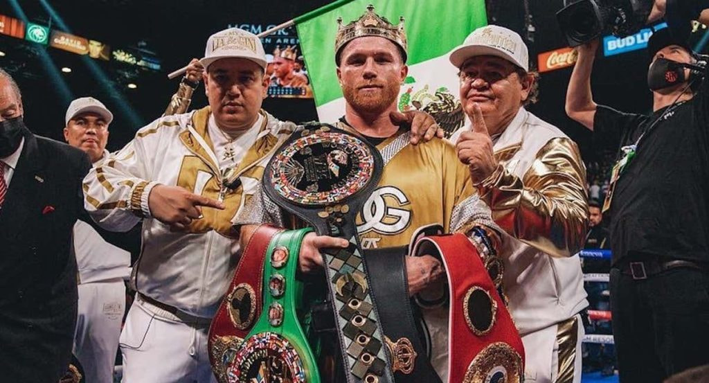 Canelo Álvarez posa con todos los cinturones del supermedio y sus entrenadores, Eddy y Chepo Reynoso, tras unificar la división.