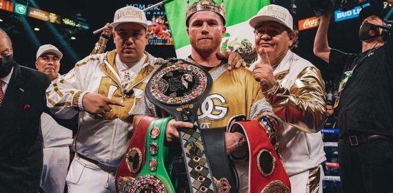 Canelo Álvarez posa con todos los cinturones del supermedio y sus entrenadores, Eddy y Chepo Reynoso, tras unificar la división.