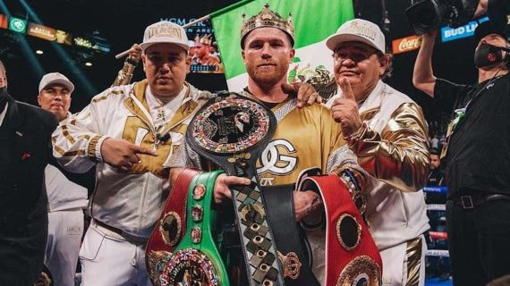 Canelo Álvarez posa con todos los cinturones del supermedio y sus entrenadores, Eddy y Chepo Reynoso, tras unificar la división.