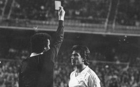 El árbitro Enríquez Negreira, enseña una de las tarjetas amarillas que supusieron la expulsión de Juanito.
