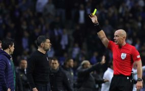 Szymon Marciniak muestra tarjeta amarilla en un partido de Champions League.