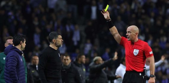 Szymon Marciniak muestra tarjeta amarilla en un partido de Champions League.