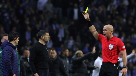 Szymon Marciniak muestra tarjeta amarilla en un partido de Champions League.