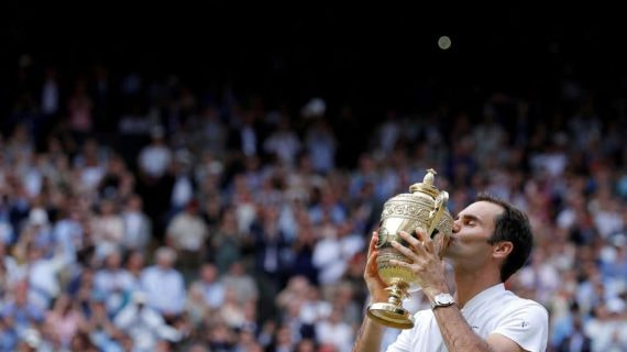 Roger Federer con su título de Wimbledon.