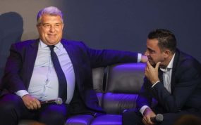Joan Laporta, presidente del Barcelona, charla con Xavi, entrenador.