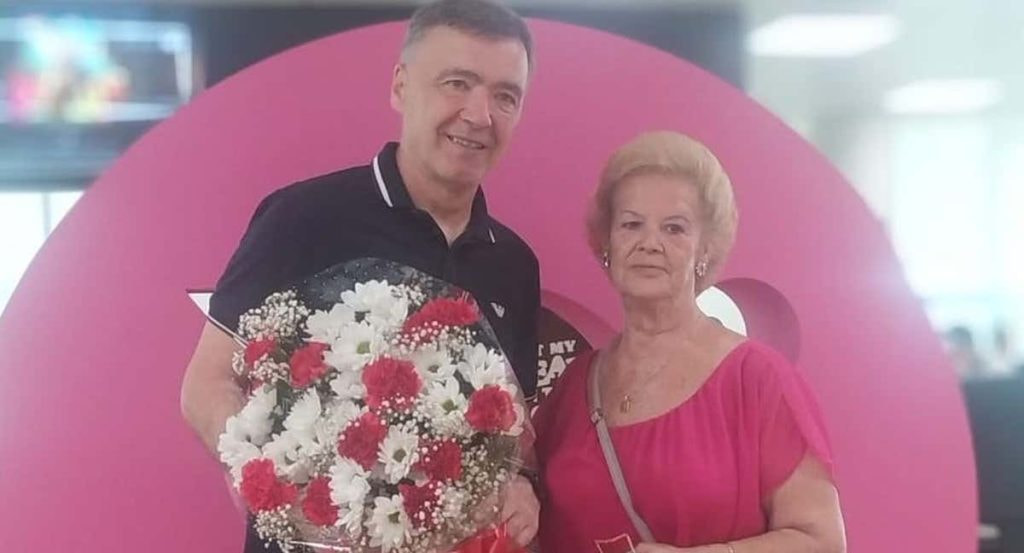 Milinko Pantic (56 años) y Margarita Luengo (76) posan juntos con el ramo de flores, en la redacción de Relevo.
