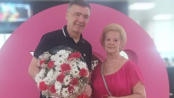 Milinko Pantic (56 años) y Margarita Luengo (76) posan juntos con el ramo de flores, en la redacción de Relevo.