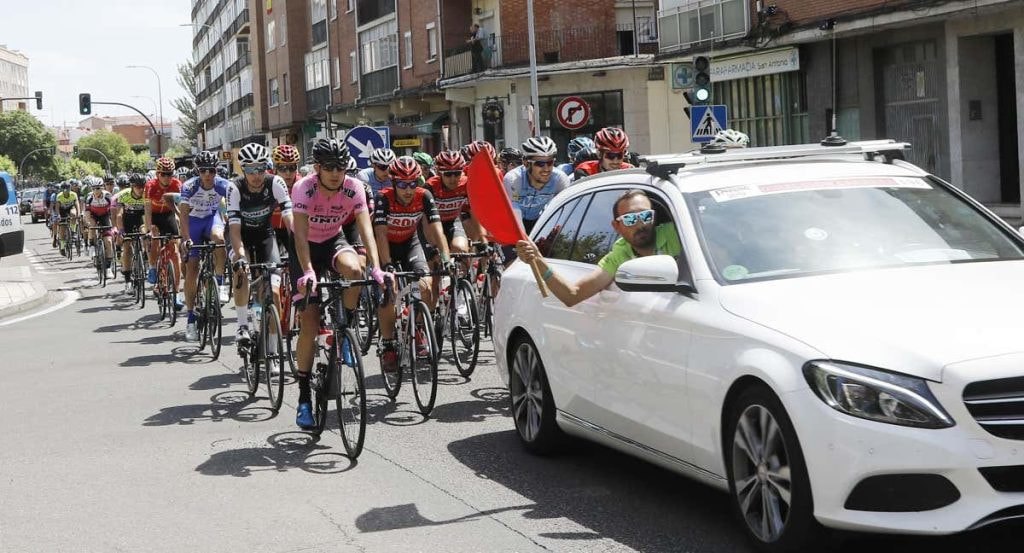 El pelotón, detrás del coche de la organización en una salida neutralizada.