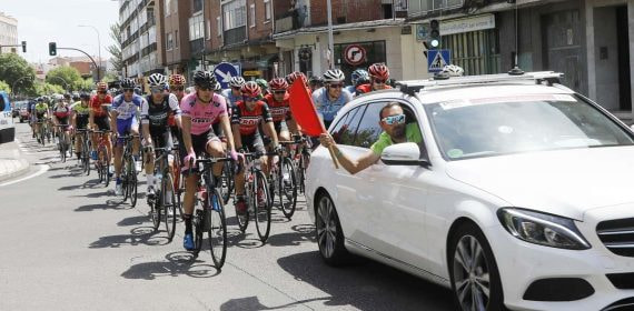 El pelotón, detrás del coche de la organización en una salida neutralizada.