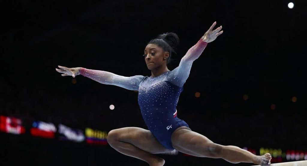 Simone BIles asombrando en la barra de equilibrio.