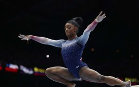 Simone BIles asombrando en la barra de equilibrio.