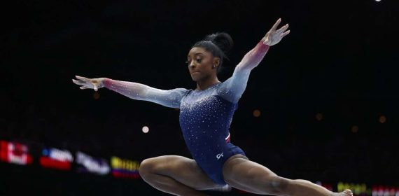 Simone BIles asombrando en la barra de equilibrio.