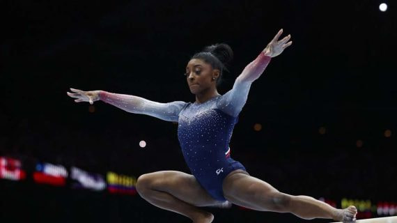 Simone BIles asombrando en la barra de equilibrio.