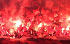 Imagen genérica de un grupo ultra con bengalas, en la grada de un estadio.