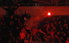 Momento en el que los ultras del Benfica lanzan una de las bengalas a la afición de la Real.