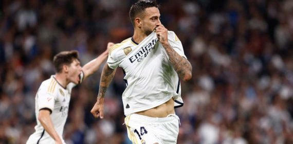 Joselu celebra un gol besando el escudo del Real Madrid.