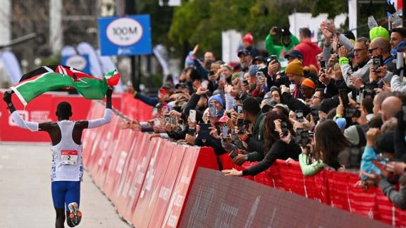 El keniano Kelvin Kiptum celebrando con la bandera de su país el récord mundial de maratón.