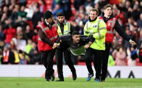 Los 'stewards' se llevan a un espontáneo en un partido de la Premier League.