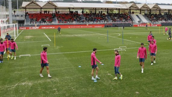 Los jugadores realizan ejercicios en el campo 2, con muchas calvas y arena.