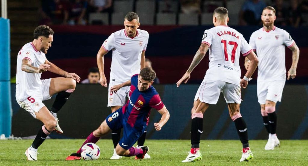 Gavi, rodeado de jugadores del Sevilla, en el choque ante el Barça de la primera vuelta.