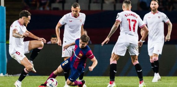 Gavi, rodeado de jugadores del Sevilla, en el choque ante el Barça de la primera vuelta.