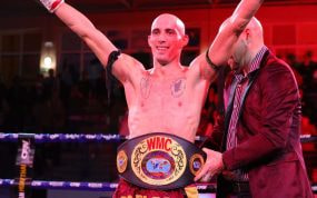 Carlos Coello festeja su victoria sobre Raksapa mientras le colocan el Campeonato del Mundo WMC.