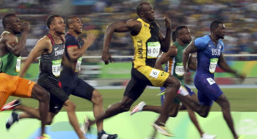 Usain Bolt y otros velocistas compiten durante una final de 100 metros lisos.