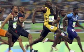 Usain Bolt y otros velocistas compiten durante una final de 100 metros lisos.