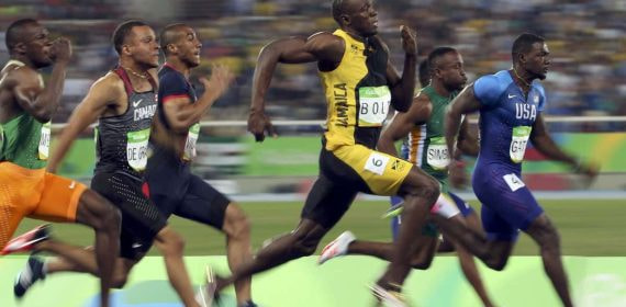 Usain Bolt y otros velocistas compiten durante una final de 100 metros lisos.