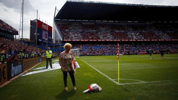 Margarita Luengo deposita unas flores en el córner del antiguo estadio del Atlético de Madrid.