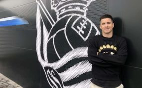 Igor Zubeldia posa con el escudo de la Real Sociedad de fondo.