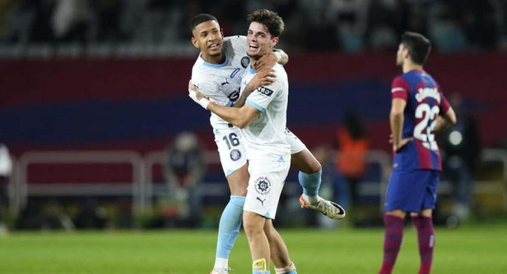 Miguel Gutiérrez y Savinho se abrazan tras la victoria del Girona en el partido de ida.