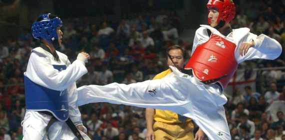 Un taekwondista recibe una patada en una competición.