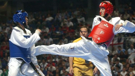 Un taekwondista recibe una patada en una competición.