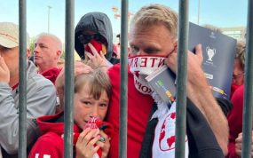 Aficionados del Liverpool se cubren ante el gas pimienta en la final de 2022.