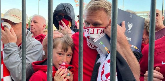 Aficionados del Liverpool se cubren ante el gas pimienta en la final de 2022.