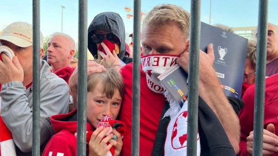 Aficionados del Liverpool se cubren ante el gas pimienta en la final de 2022.