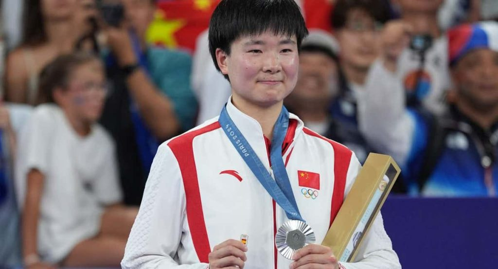 He Binjiao, con su medalla de plata y su pin de España en memoria de Carolina Marín, lesionada en la semifinal.