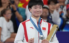 He Binjiao, con su medalla de plata y su pin de España en memoria de Carolina Marín, lesionada en la semifinal.