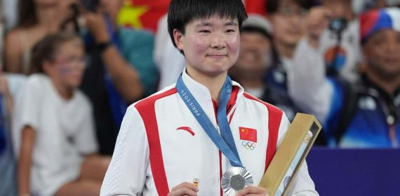 He Binjiao, con su medalla de plata y su pin de España en memoria de Carolina Marín, lesionada en la semifinal.