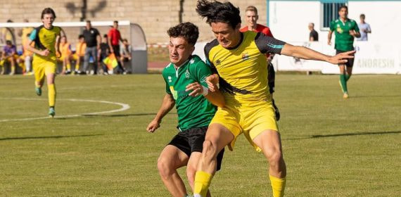 Un jugador del Mojados, de amarillo, disputa el balón en un partido contra el Villamuriel.