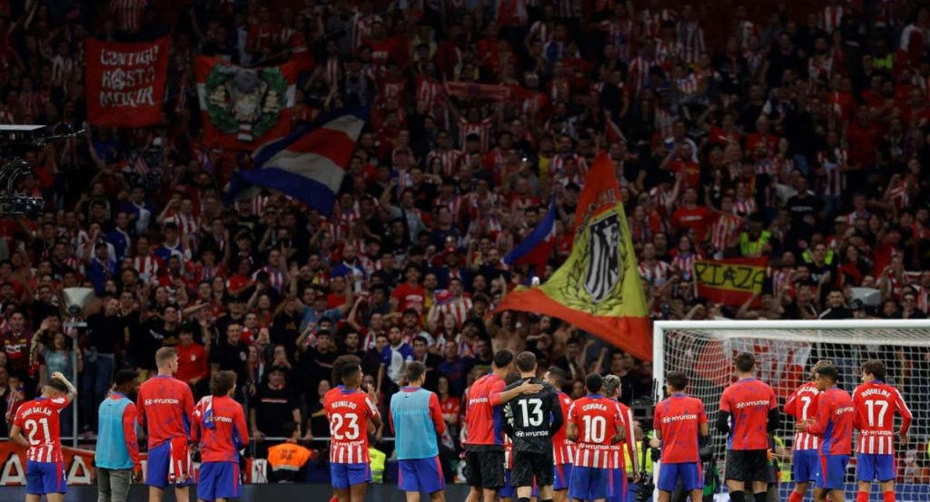 Los jugadores del Atlético hablan con el fondo.