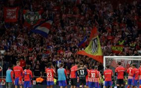 Los jugadores del Atlético hablan con el fondo.