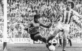 Santi Idígoras, en un partido con la Real Sociedad, intentando regatear a Andoni Cedrún.