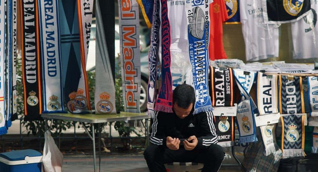 Un vendedor mira su teléfono móvil antes del Real Madrid-Alavés del pasado martes.