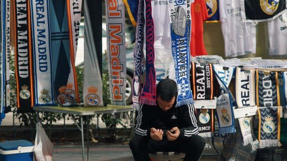Un vendedor mira su teléfono móvil antes del Real Madrid-Alavés del pasado martes.