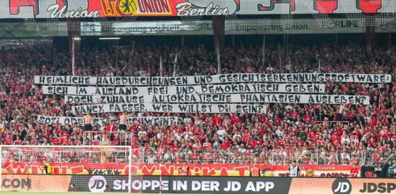 Aficionados del Union sostienen pancartas en un partido en Berlín.