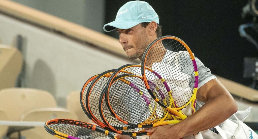 Rafael Nadal entra a la pista central de Roland Garros con sus raquetas para un entrenamiento en 2022.